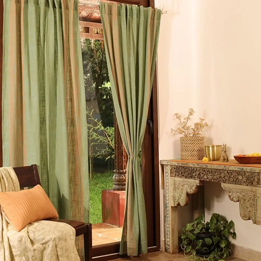 Design inspiration: sage and rust striped curtains beside a carved console table