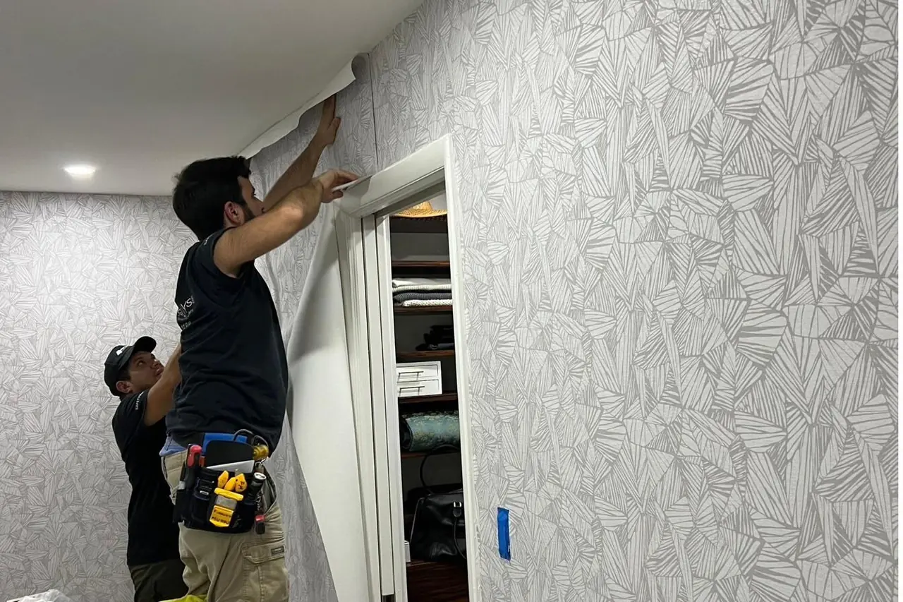 Illustration of two people fitting wallpaper to a wall